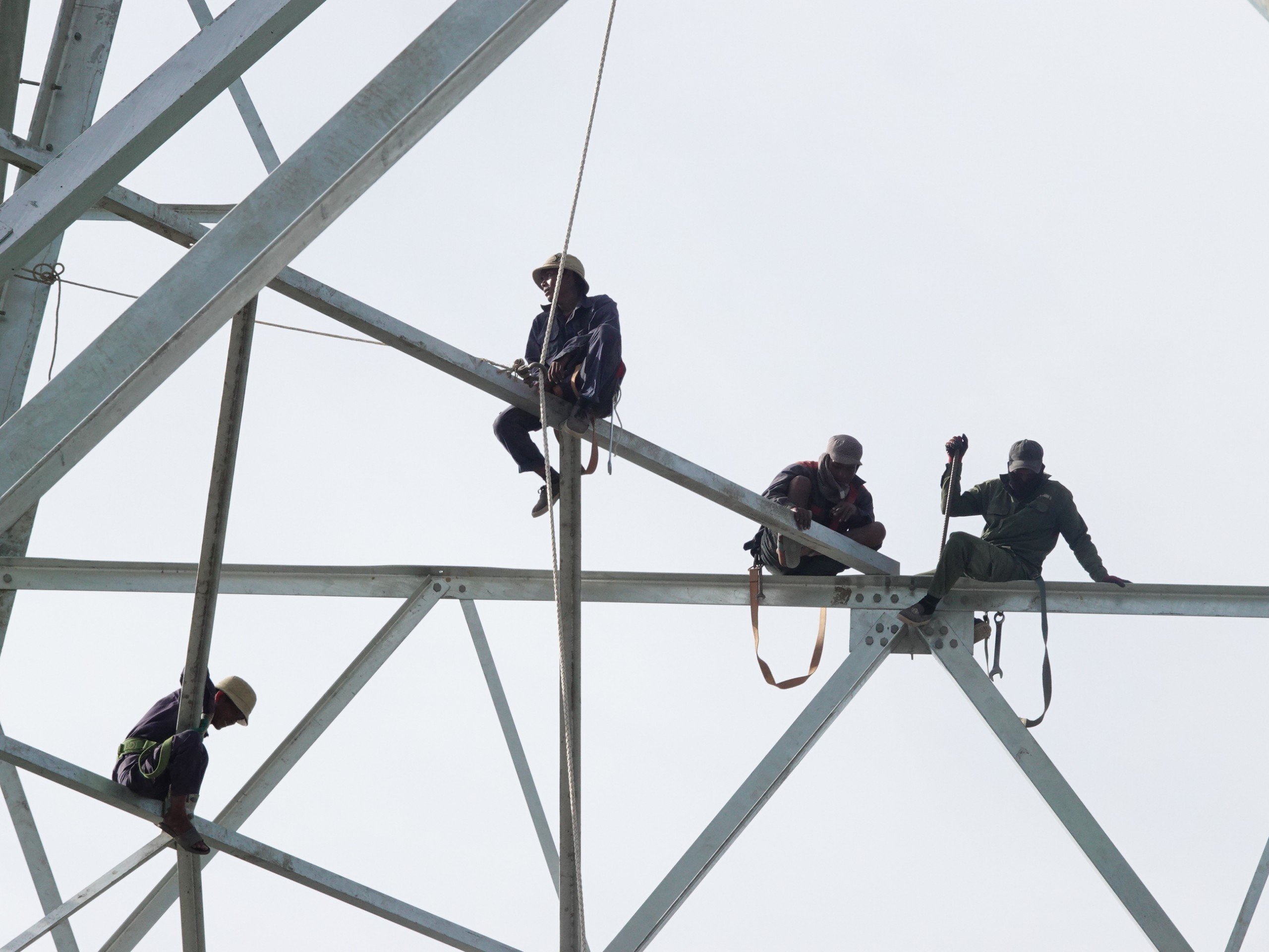 Các công nhân kỹ thuật thi công trên cao để lắp đặt cột điện