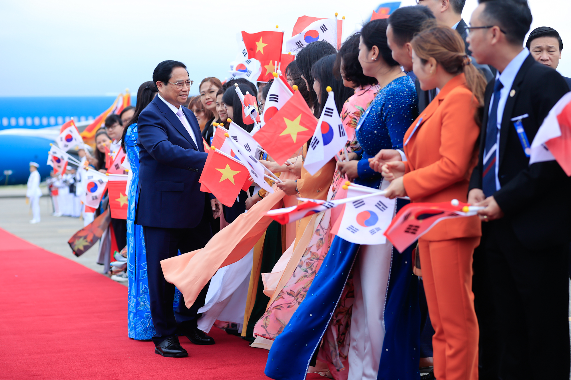 Cán bộ, nhân viên Đại sứ quán và cộng đồng người Việt Nam tại Hàn Quốc nồng nhiệt chào đón Thủ tướng và Phu nhân, cùng Đoàn đại biểu Việt Nam. Ảnh: VGP.