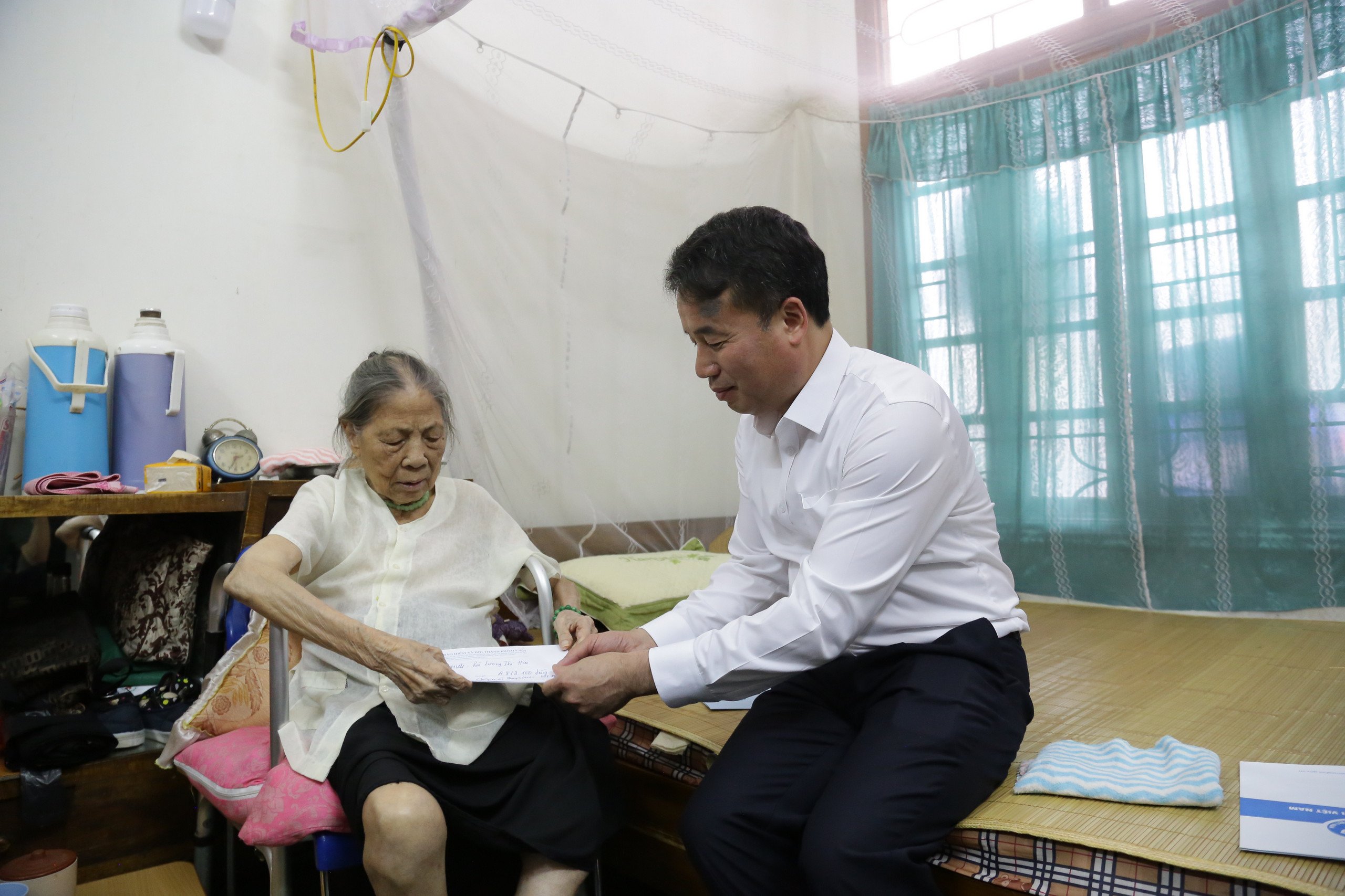 Tổng Giám đốc Bảo hiểm xã hội Việt Nam Nguyễn Thế Mạnh trao lương hưu tại nhà cho bà Lương Thị Hai (Hà Đông, Hà Nội).
