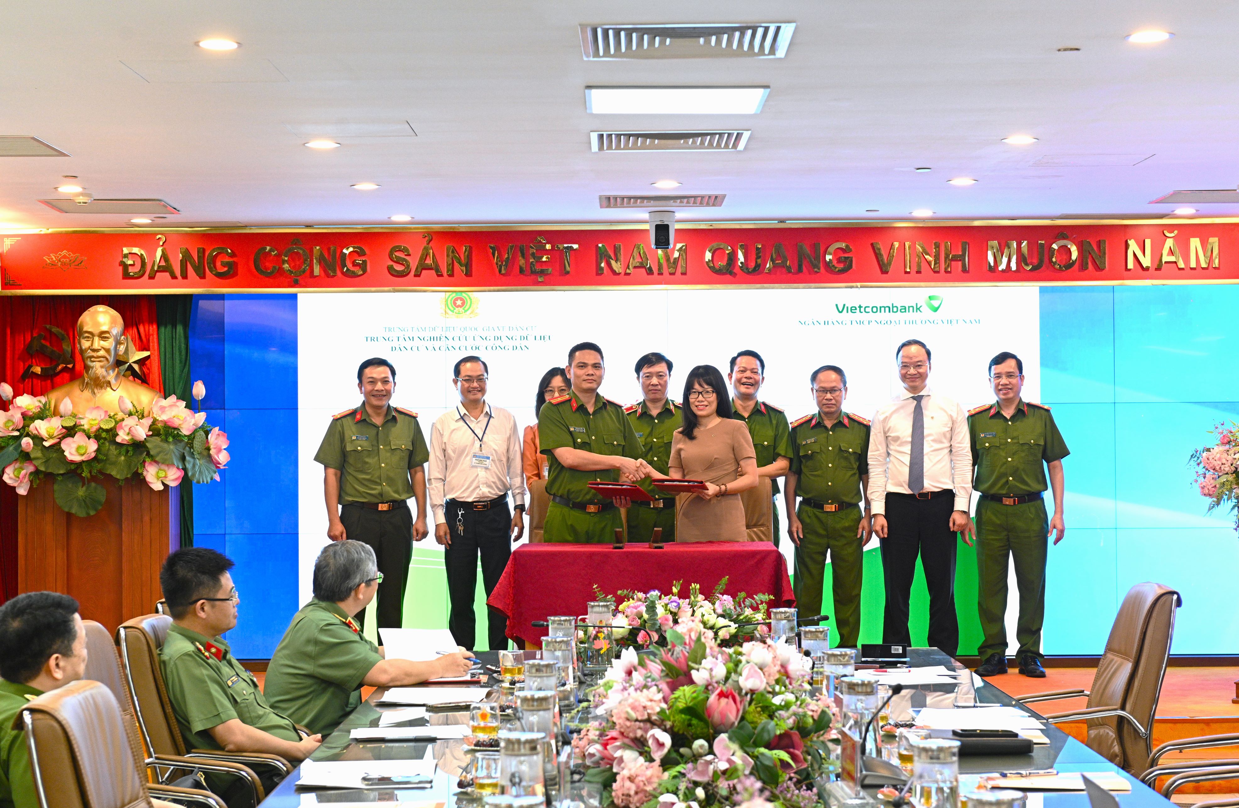 Bà Đoàn Hồng Nhung - Giám đốc Khối Bán lẻ Vietcombank và Thiếu tá Trần Duy Hiển - Giám đốc Trung tâm Nghiên cứu, ứng dụng dữ liệu dân cư và căn cước công dân (RAR) đại diện hai bên ký kết “Dịch vụ xác thực điện tử”.