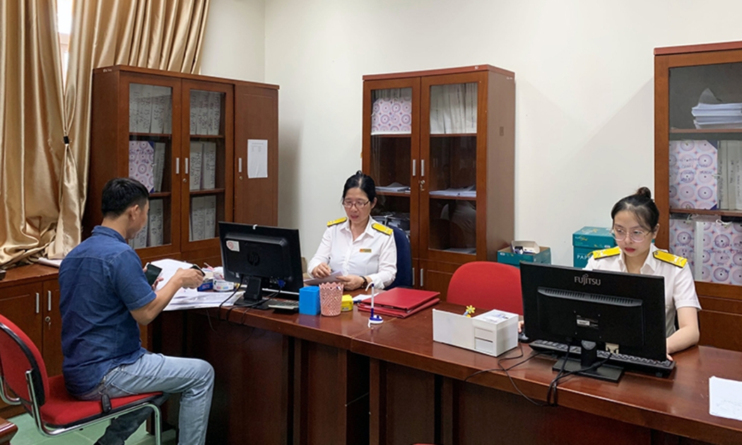 Cán bộ cục Thuế Quảng Bình Hỗ trợ người nộp thuế thực hiện các thủ tục kê khai thuế. Ảnh Báo Quảng Bình