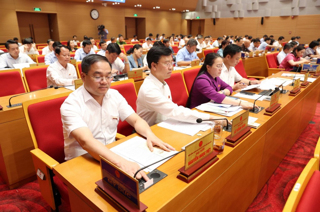 C&aacute;c đại biểu bấm n&uacute;t th&ocirc;ng qua Nghị quyết.