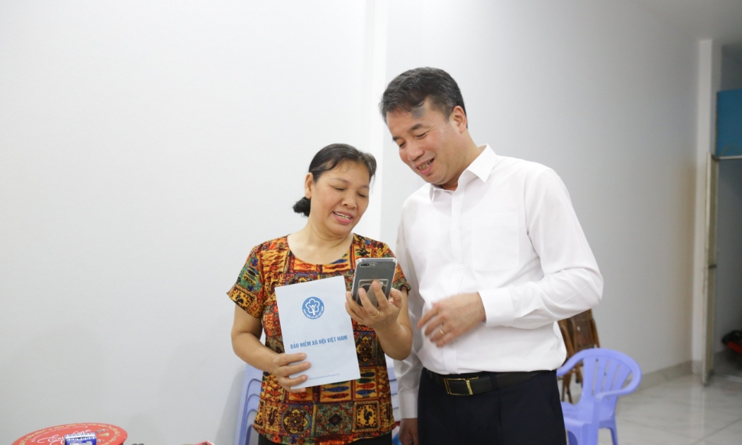 Tổng Giám đốc Bảo hiểm xã hội Việt Nam Nguyễn Thế Mạnh chia sẻ với người nhận lương hưu tại Hà Nội. Ảnh: Duy Nguyễn.