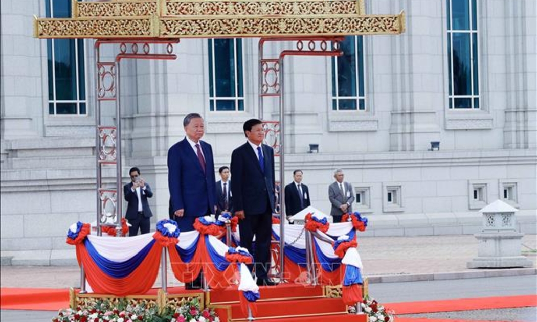 Chủ tịch nước Tô Lâm và Tổng Bí thư, Chủ tịch nước Lào Thongloun Sisoulith trên bục danh dự, nghe quân nhạc cử Quốc thiều hai nước - Ảnh: TTXVN