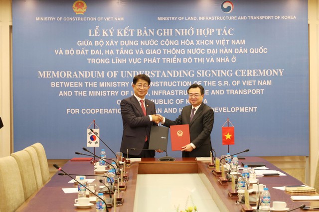 Minister of Construction Nguyen Thanh Nghi (R) and Minister of of Land, Infrastructure and Transport Park Sangwoo exchange a memorandum of understanding (MoU) on urban and housing development, in Hanoi on July 16. Photo: VNA 