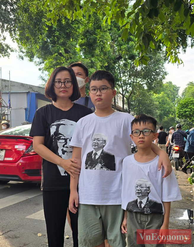 Ba mẹ con chị Nguyễn Thị Thu Ngân (quận Đống Đa, Hà Nội) mặc áo có in hình chân dung Tổng Bí thư Nguyễn Phú Trọng để xếp hàng vào viếng.