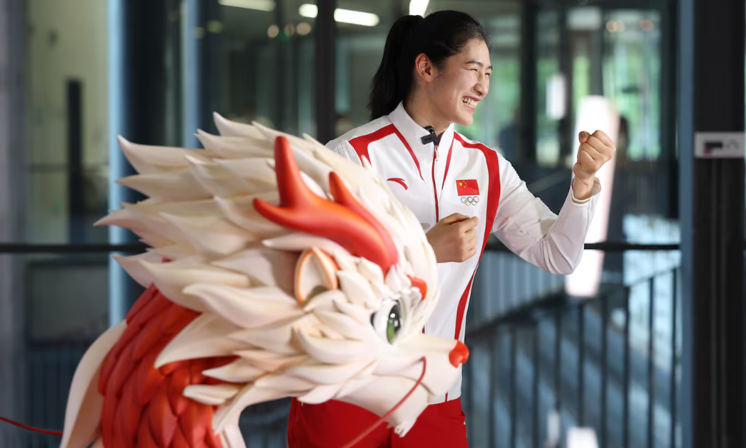 Võ sĩ Trung Quốc Li Qian khoe đồng phục lễ trao huy chương của đoàn Trung Quốc, do thương hiệu Anta tài trợ. Ảnh: BoF