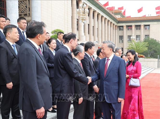Tổng Bí thư, Chủ tịch nước Tô Lâm và Phu nhân bắt tay các thành viên chính thức Đoàn đại biểu Trung Quốc tại Lễ đón - Ảnh: TTXVN