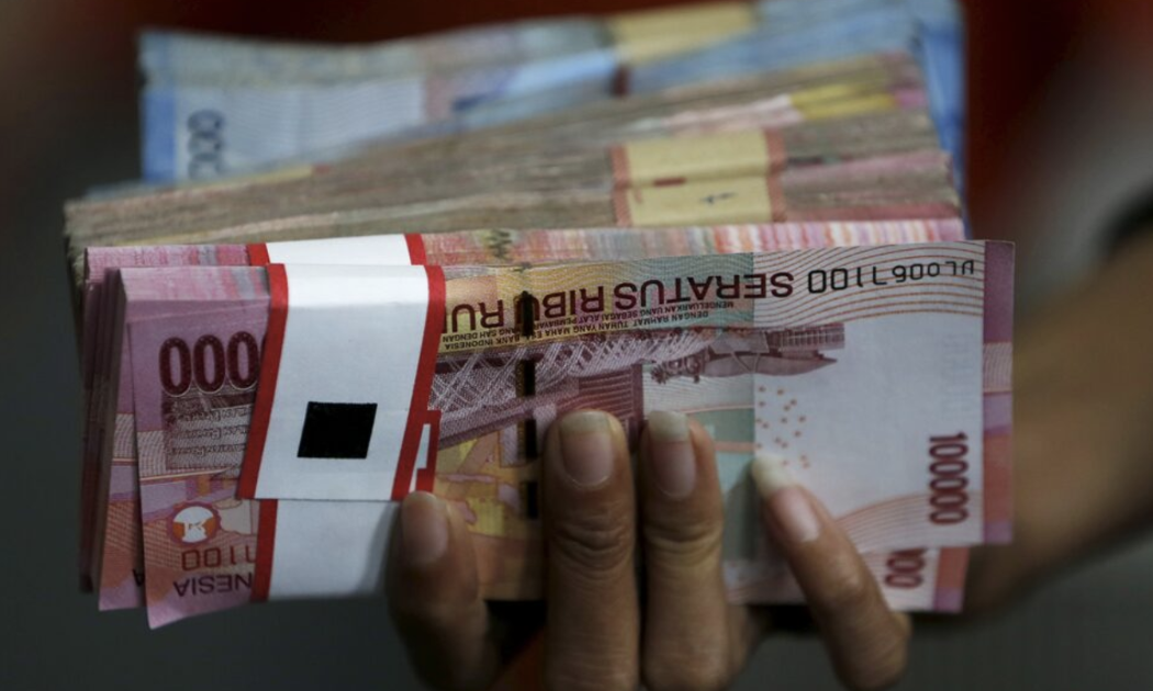 Một xấp tiền rupiah Indonesia - Ảnh: Reuters.
