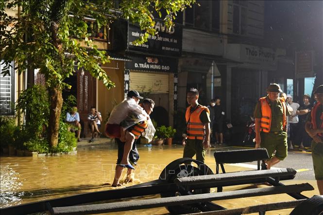 Lực lượng công an thành phố Yên Bái giúp người dân phường Hồng Hà di chuyển ra khỏi khu vực ngập úng trong đêm 8/9. Ảnh: TTXVN 