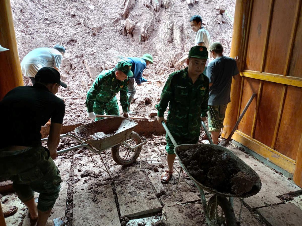 Cán bộ, chiến sĩ Đồn Biên phòng Mỹ Lý hỗ trợ nhân dân giải phóng đất đá tràn vào nhà. Ảnh: Hải Thượng