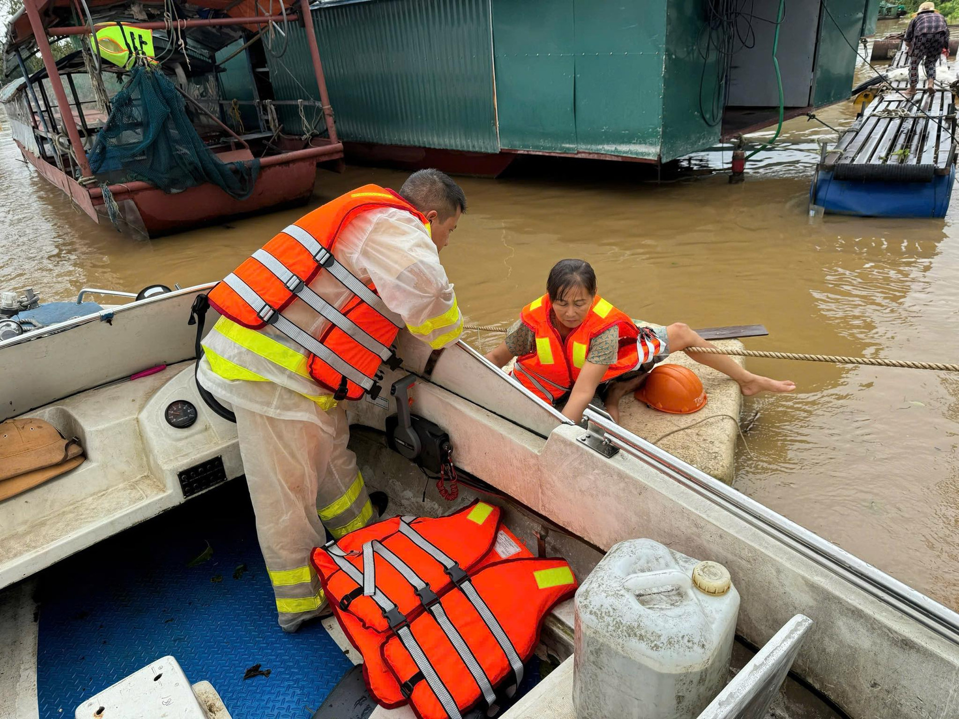 Cảnh sát giao thông tặng áo phao và nhu yếu phẩm cho bà con sinh sống ven sông Hồng. Ảnh: VGP