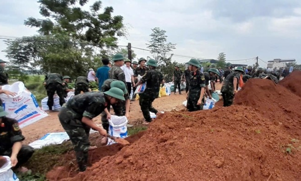  Bộ đội Trung đoàn 48 phối hợp với các lực lượng địa phương đắp đê ngăn lũ tại xã Hà Bắc tróng sáng ngày 13/9.  Ảnh Nguyễn Tiến