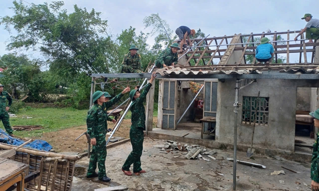 Các cán bộ, chiến sĩ Đồn Biên phòng Thiên Cầm (Hà Tĩnh) giúp người dân sửa lại nhà cửa do lốc xoáy gây ra. Ảnh Dương Quang