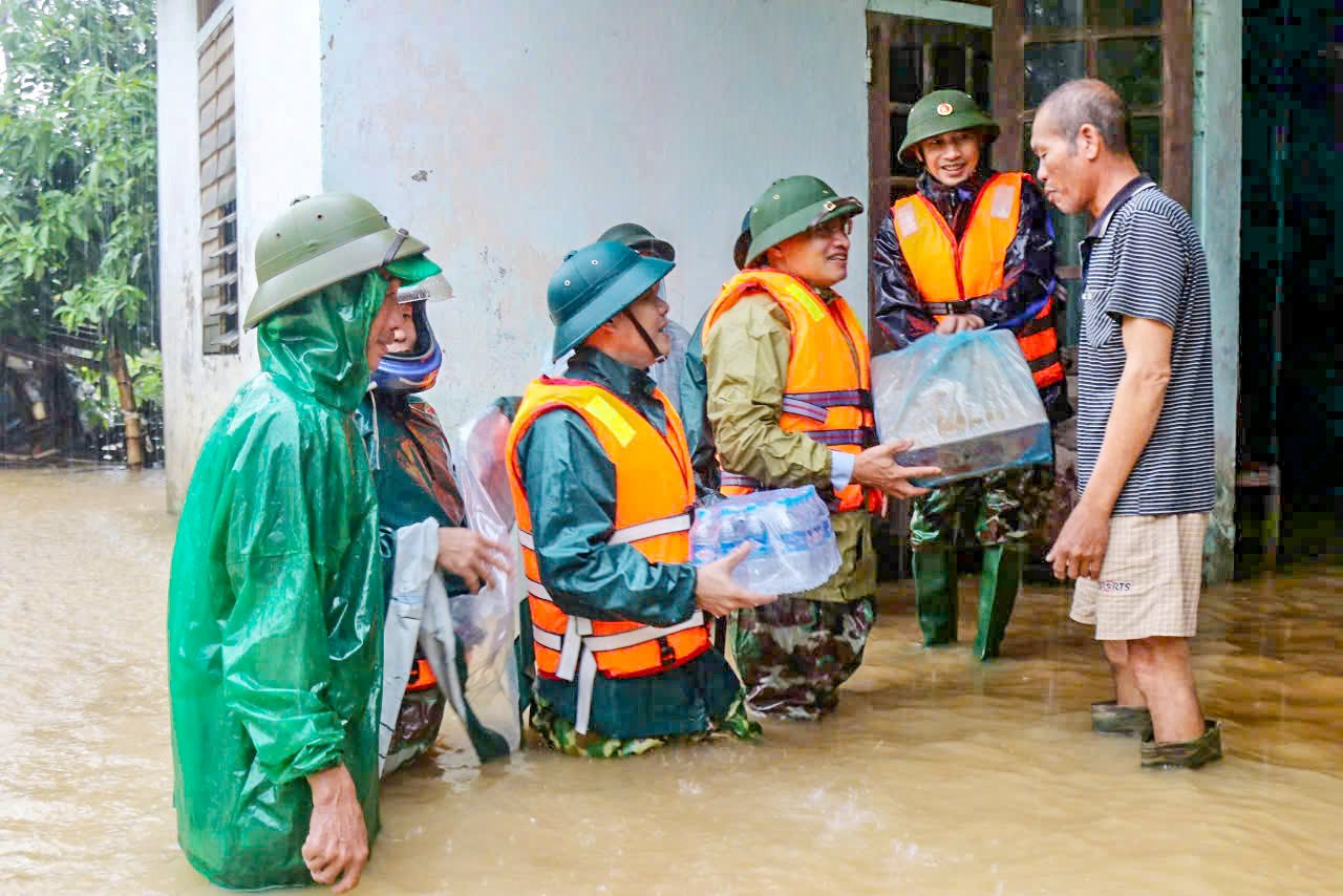 Lực lượng chức năng huyện Nghi Xuân (Hà Tĩnh) đi kiểm tra và hỗ trợ người dân thôn Hồng Lam, xã Xuân Lam nước uống và mỳ tôm trong những mưa lũ vừa qua