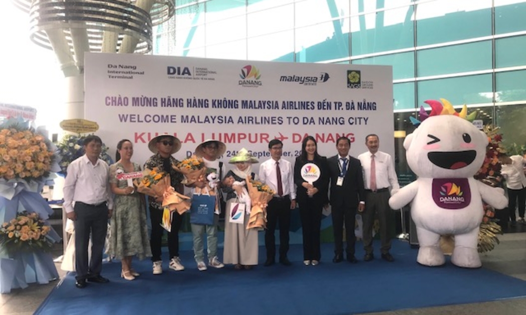 Đại diện lãnh đạo Sở Du lịch thành phố Đà Nẵng và các đơn vị ngành hàng không đón chào và tặng quà lưu niệm khách Malaysia. Ảnh Ngô Anh Văn