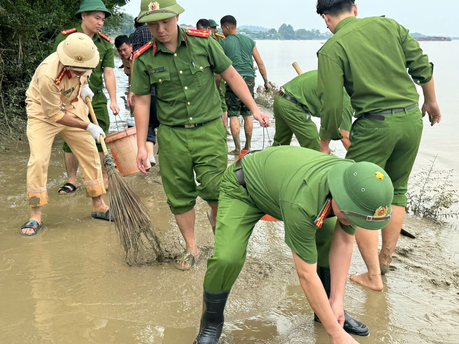  Các chiến sỹ công an thành phố Thanh Hóa xử lý bùn đất trên các tuyến đường để giao thông được thông suốt, đảm bảo an toàn và mỹ quan.