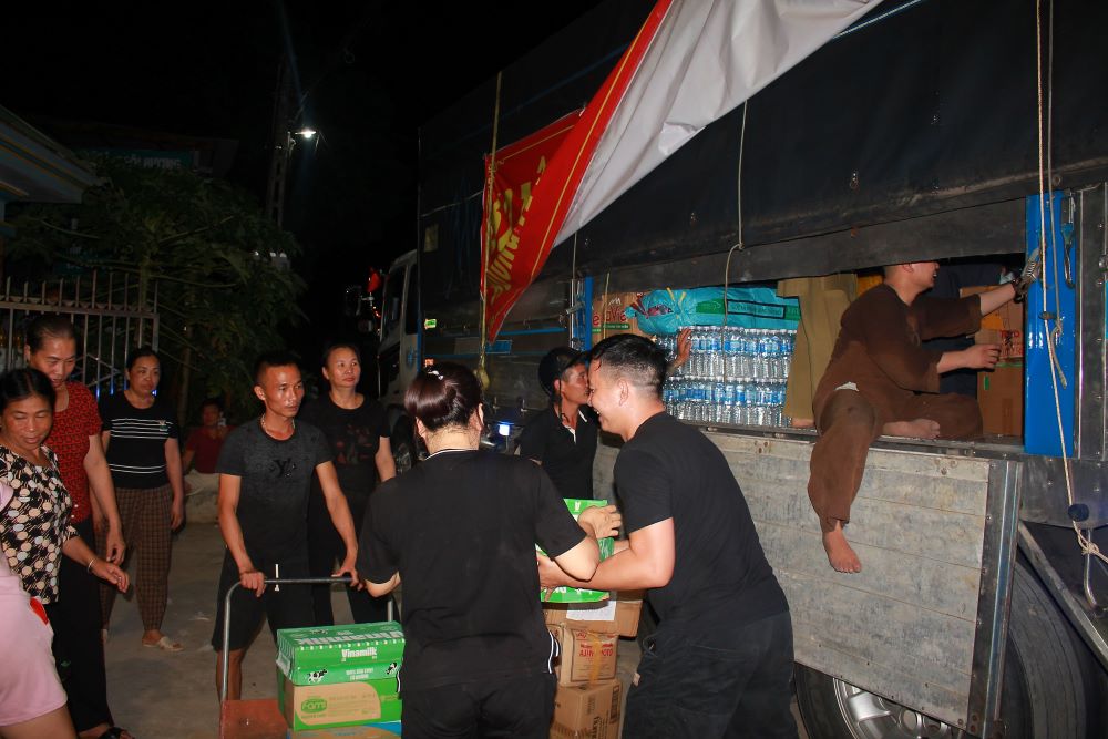 Người dân bốc  dỡ hàng cứu trợ từ các xe xuống vào ban đêm. Ảnh: Chu Khôi.