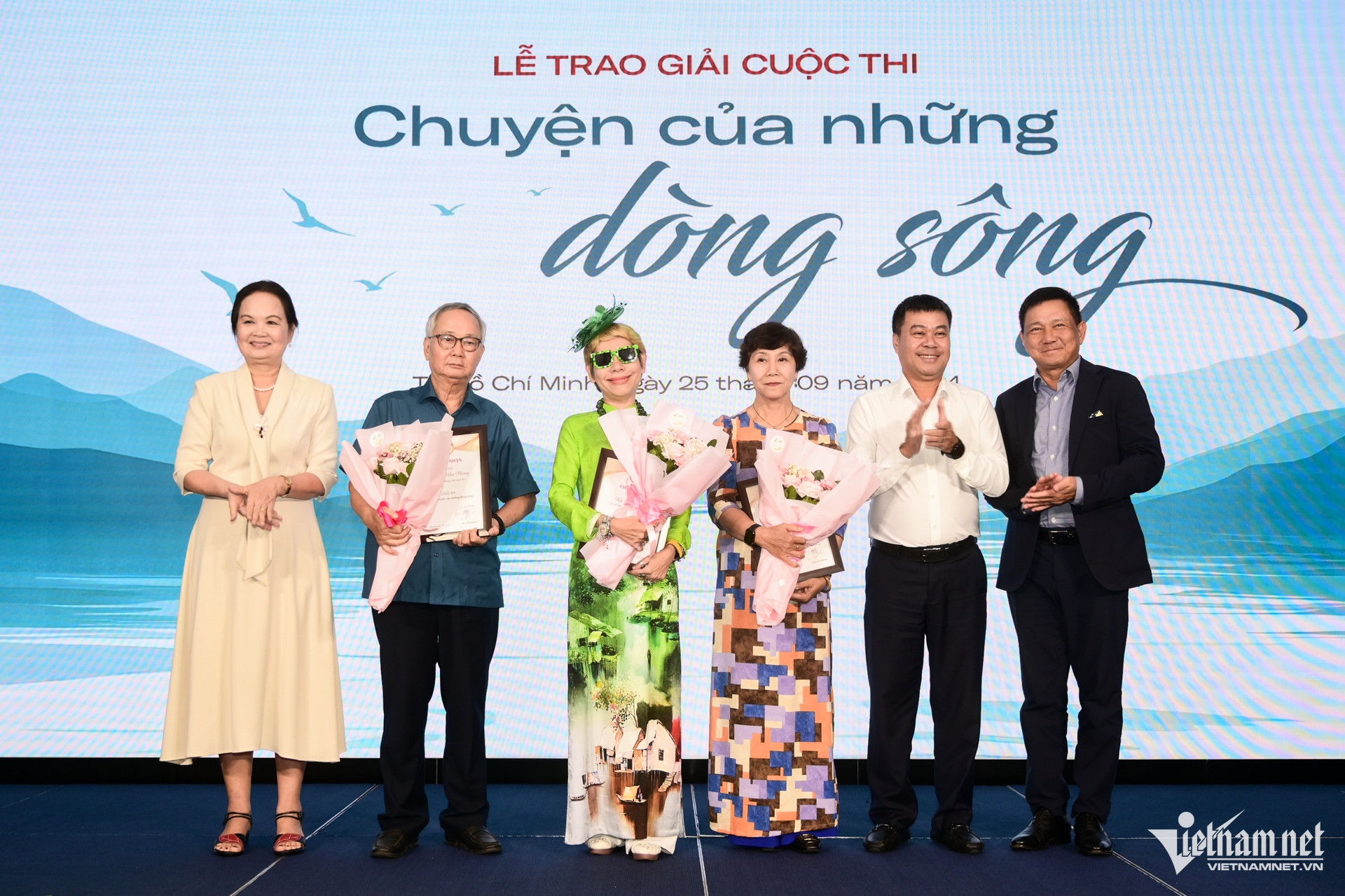 Ông Nguyễn Văn Bá - Tổng biên tập báo VietNamNet (thứ 2 từ phải qua), bà Trịnh Bích Ngân - Chủ tịch Hội Nhà văn TPHCM (ngoài cùng bên trái), ông Đặng Bảo Hiếu - Chủ tịch HĐQT Ana Marina Nha Trang (ngoài cùng bên phải) trao giải Ba cho nhóm tác giả. Ảnh: Nguyễn Huế.