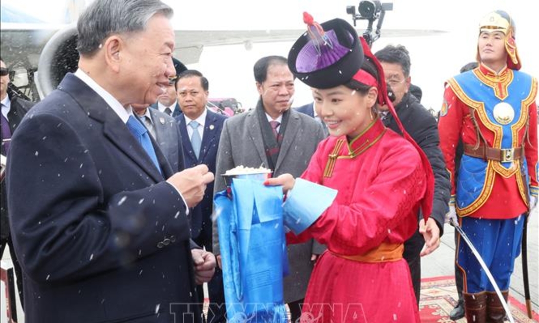 Thiếu nữ Mông Cổ trân trọng mời bánh sữa theo phong tục truyền thống và tặng hoa đón Tổng Bí thư, Chủ tịch nước Tô Lâm tại sân bay Thành Cát Tư Hãn ở Thủ đô Ulaanbaatar - Ảnh: TTXVN
