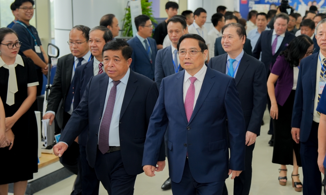 Thủ tướng Phạm Minh Chính và Bộ trưởng Bộ Kế hoạch và Đầu tư đi thăm các gian hàng trưng bày tại NIC trước khi dự Lễ kỷ niệm 5 năm thành lập NIC. Ảnh: MPI.