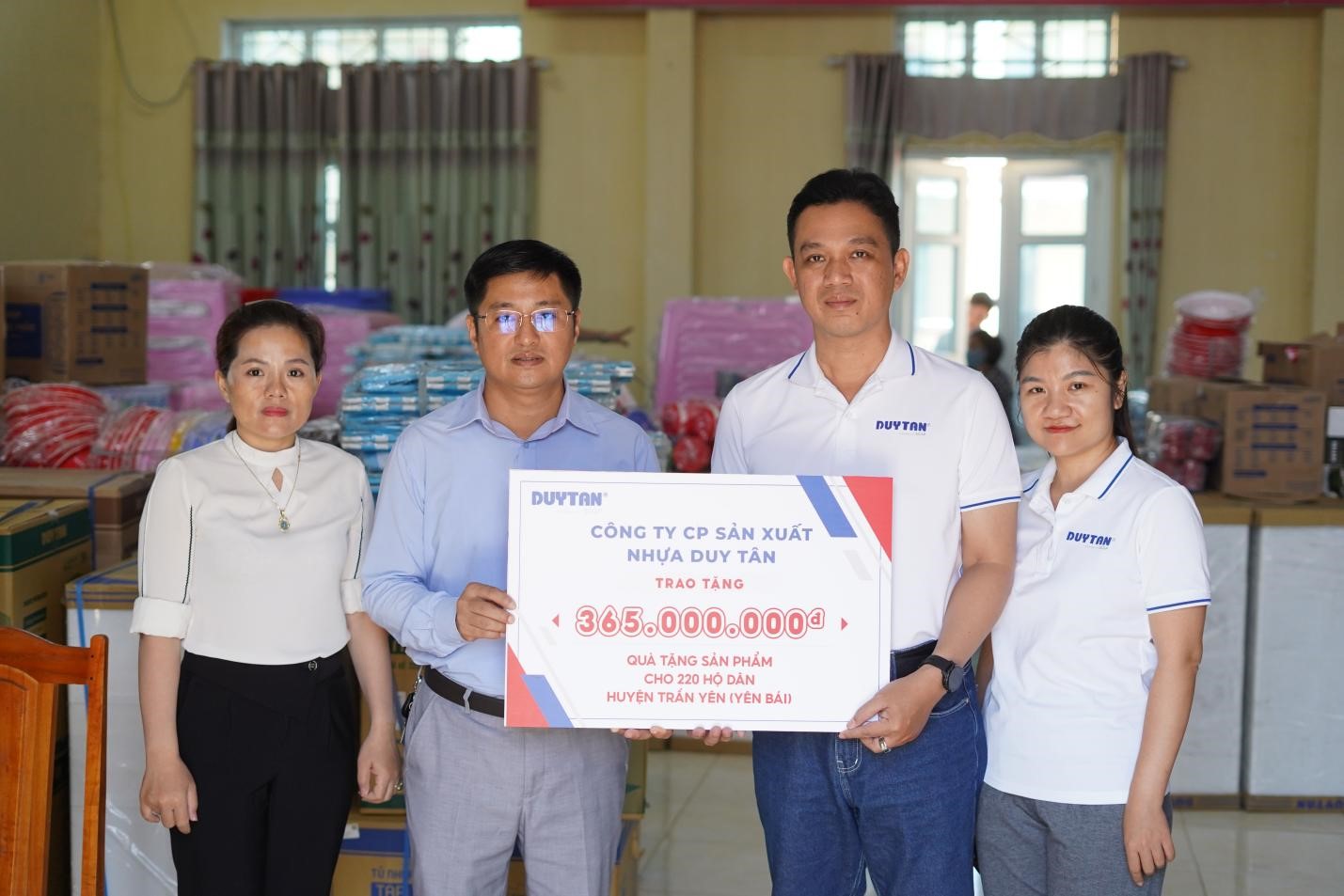 Ông Nguyễn Ngọc Thành, Giám đốc Marketing Nhựa Duy Tân trao tặng biểu trưng cho Ông Nguyễn Cảnh Hiếu (bên trái), Chủ tịch Ủy ban MTTQ  huyện Trấn Yên.