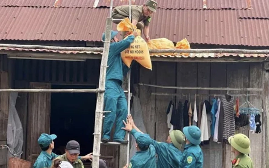 Lực lượng Công an, dân phòng Quảng Nam giúp dân gia cố nhà cửa chống bão Trài Mi. Ảnh CA Quảng Nam cung cấp.