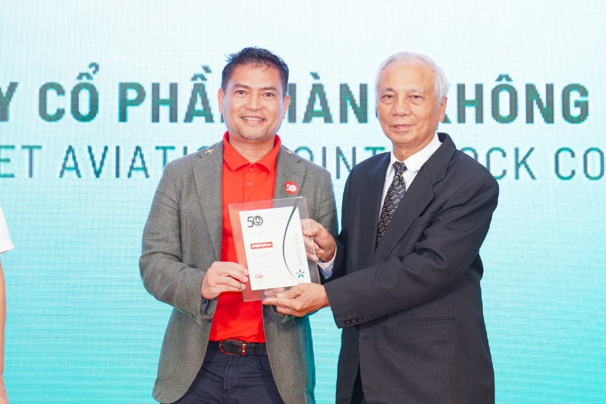 Ông Nguyễn An Di - Giám đốc Nhân sự Vietjet (áo T - shirt đỏ, áo khoác ghi xám) nhận giải thưởng tôn vinh Top 50 doanh nghiệp phát triển bền vững từ ban tổ chức.
