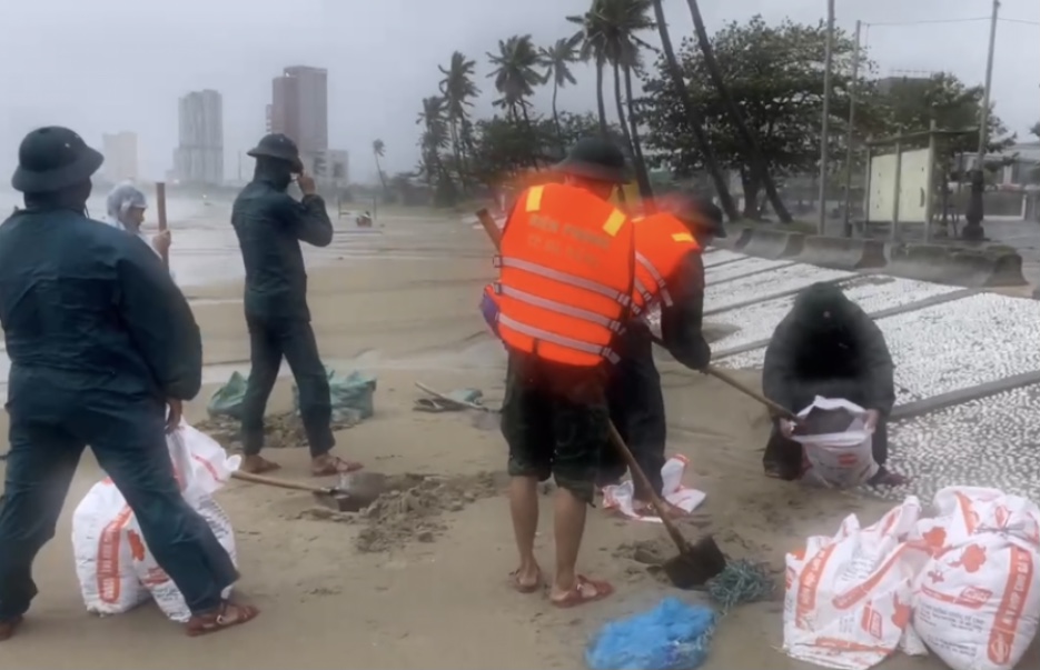 Bộ đội Bi&ecirc;n ph&ograve;ng v&agrave;o bao c&aacute;t chằn m&aacute;i nh&agrave; lợp t&ocirc;n gi&uacute;p d&acirc;n ở ven biển chống hư hỏng do mưa lũ.