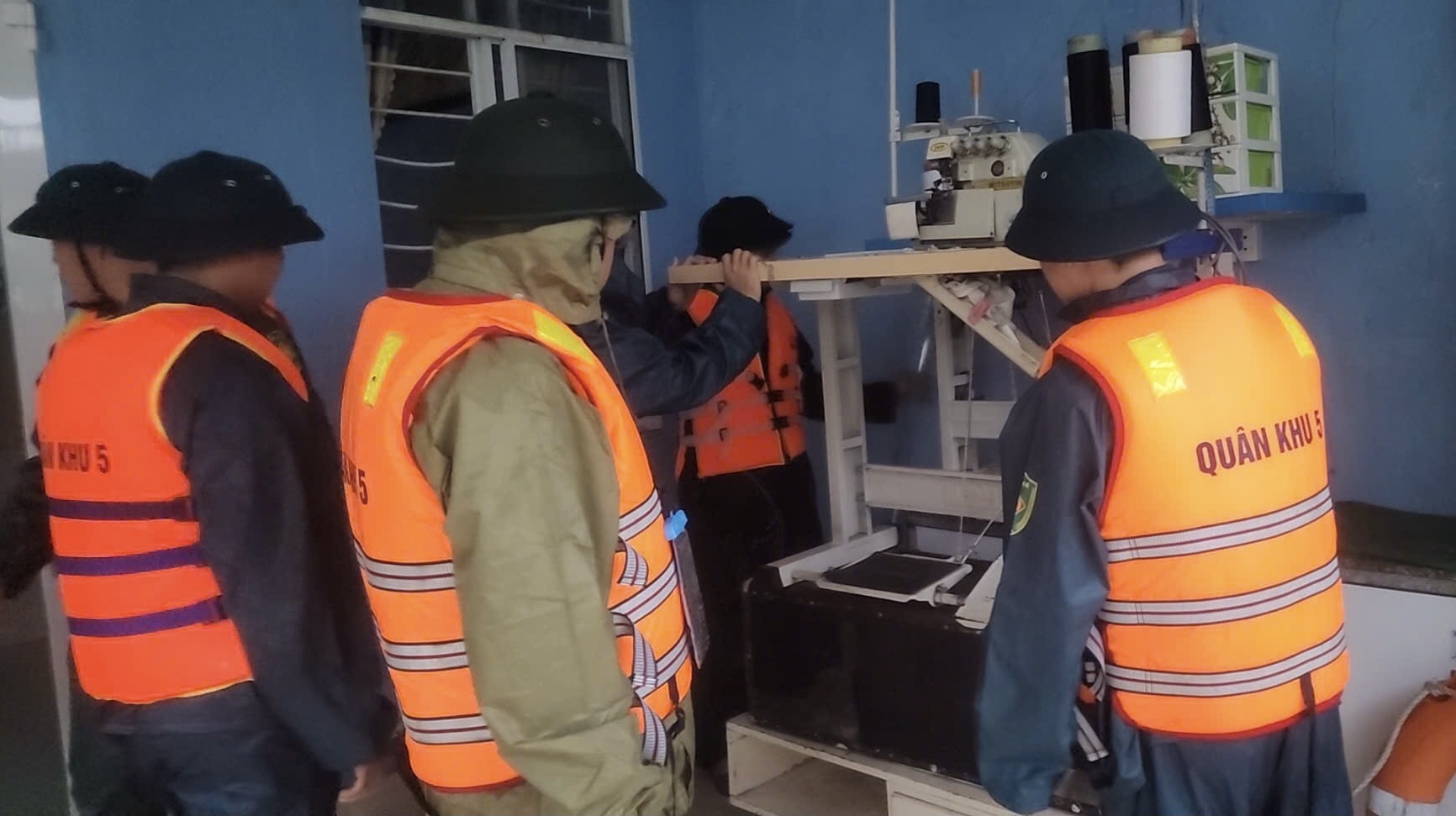Cán bộ chiến sỹ Bộ Chỉ huy quân sự TP. Đà Nẵng giúp dân kê cao đồ tránh ngập do mưa lớn nước tràn vào nhà dân trên đường Mẹ Suốt.