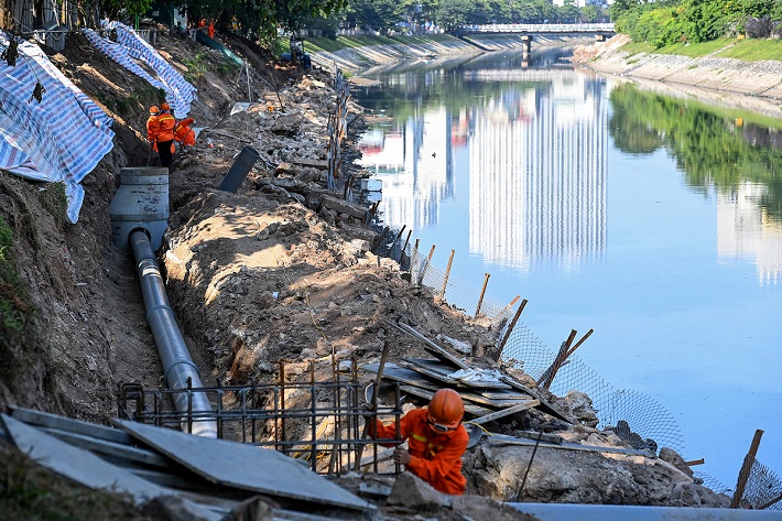 Công nhân thi công hệ thống ống thu gom nước thải ra sông Tô Lịch.