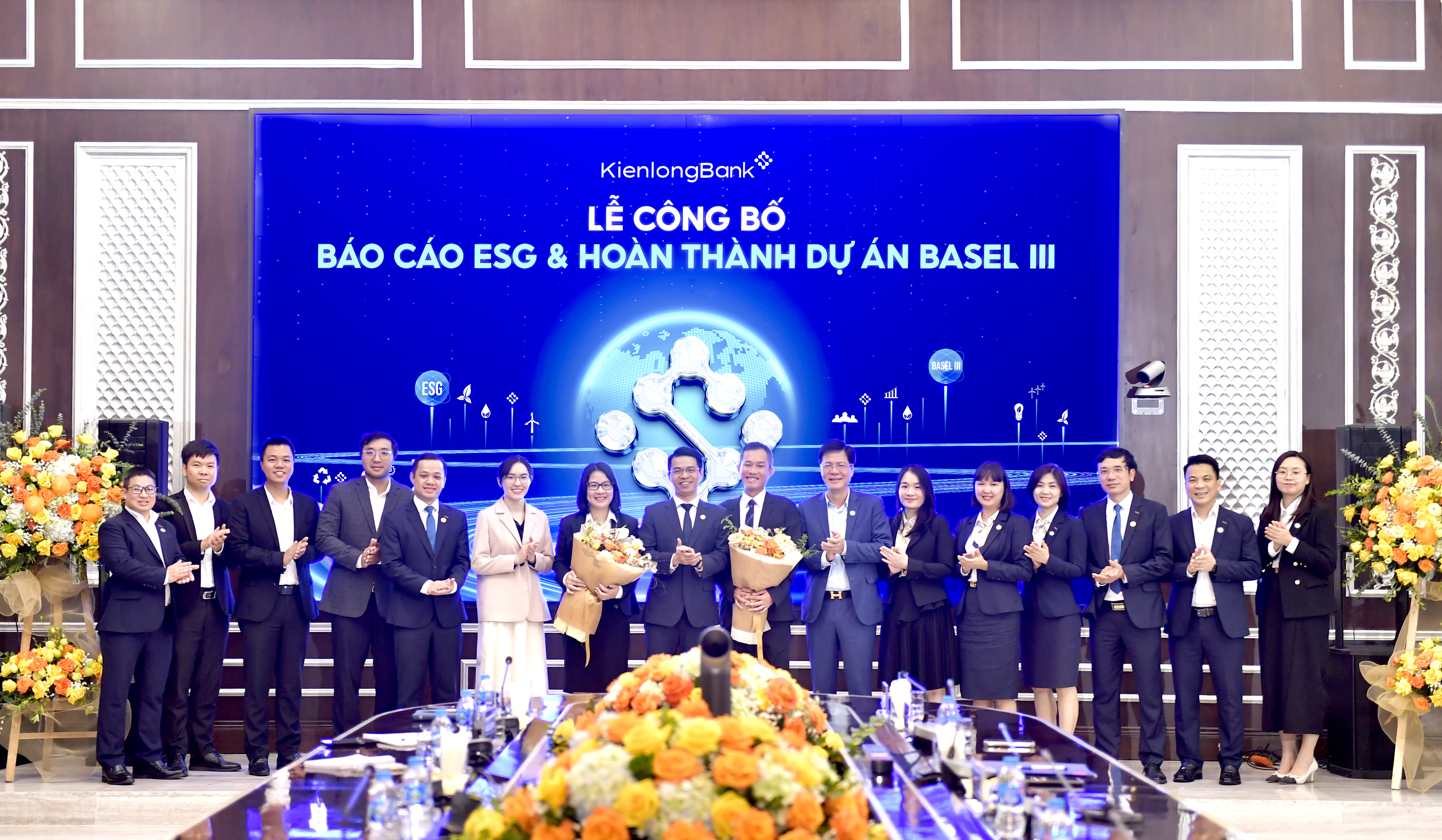 Ông Trần Ngọc Minh - Chủ tịch HĐQT KienlongBank và ông Trần Hồng Minh - Quyền Tổng giám đốc KienlongBank trao hoa cảm ơn và chúc mừng hai đối tác cùng Ban Dự án.