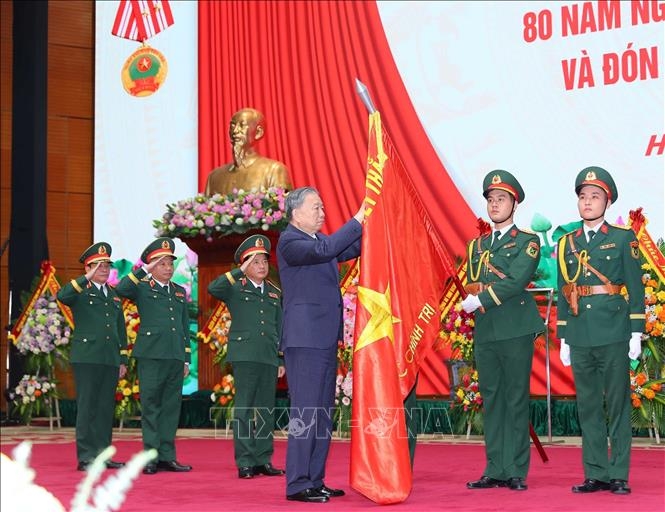 Tổng B&iacute; thư T&ocirc; L&acirc;m gắn Hu&acirc;n chương Độc lập hạng Nhất l&ecirc;n l&aacute; cờ truyền thống của Tổng cục Ch&iacute;nh trị QĐND Việt Nam. Ảnh: TTXVN