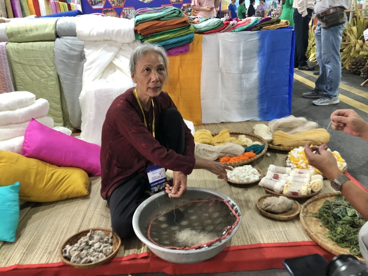 Nghệ nh&acirc;n l&agrave;ng nghề lụa, đũi Nam Cao (Th&aacute;i B&igrave;nh) t&aacute;i hiện hoạt động se sợi. Ảnh: PA.