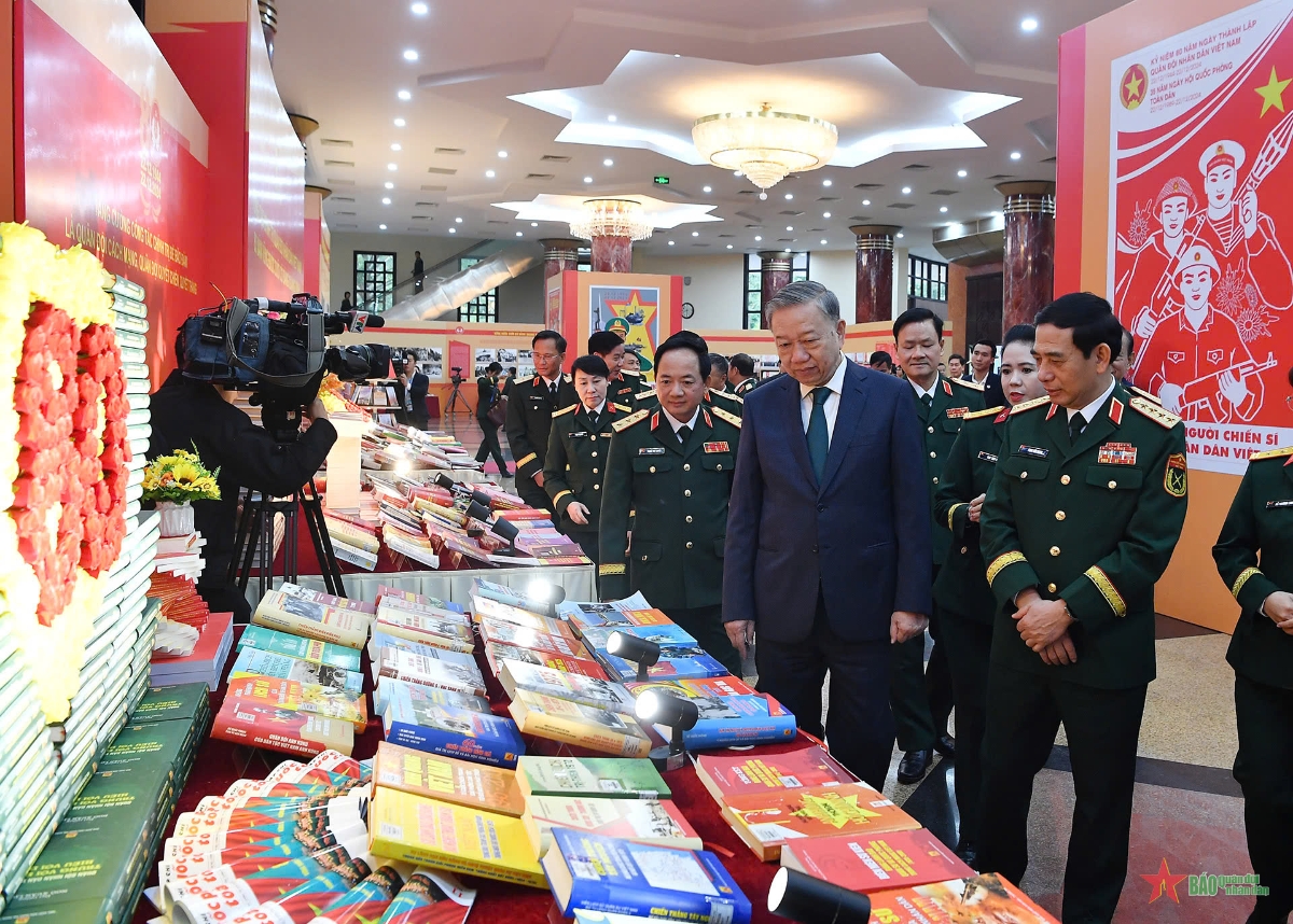 &nbsp;Tổng B&iacute; thư T&ocirc; L&acirc;m, l&atilde;nh đạo Bộ Quốc ph&ograve;ng v&agrave; c&aacute;c đại biểu tham quan gian trưng b&agrave;y s&aacute;ch b&aacute;o phục vụ Lễ kỷ niệm. Ảnh: B&aacute;o QĐND