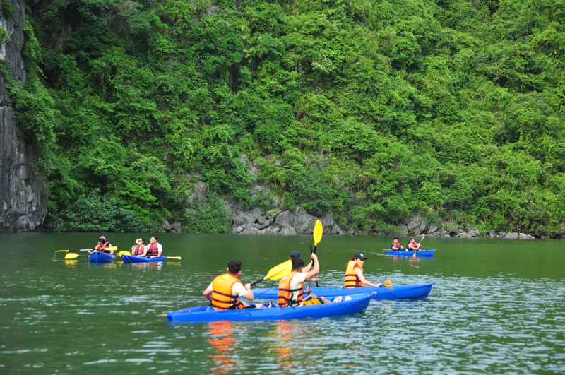 Kh&aacute;ch du lịch ch&egrave;o thuyền Kayak tham quan Hang Luồn, Vịnh Hạ Long.
