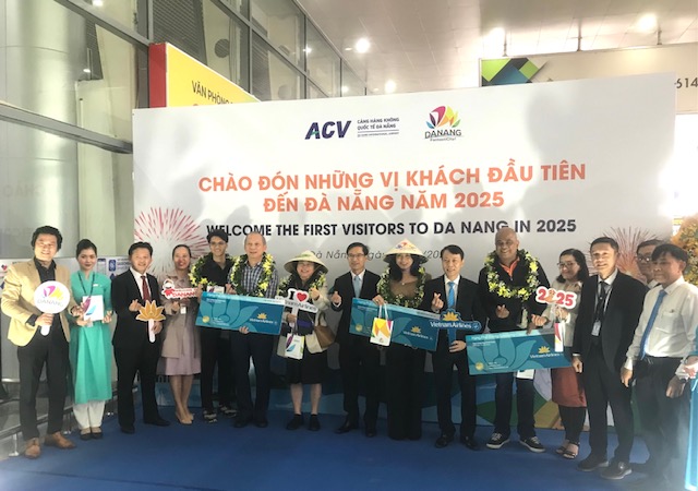 Lãnh đạo Sở Du lịch và các đơn vị ngành Hàng không tại Đà Nẵng chào đón và tặng quà những vị khách đầu tiên đến Đà Nẵng sáng 01/01/2025. Ảnh: Ngô Anh Văn