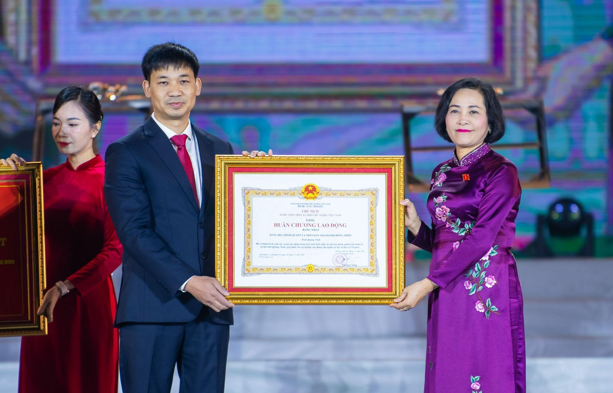 Đồng ch&iacute; Nguyễn Thị Thanh trao Quyết định của Chủ tịch nước tặng Hu&acirc;n chương Lao động hạng Nhất cho Đảng bộ, ch&iacute;nh quyền v&agrave; nh&acirc;n d&acirc;n th&agrave;nh phố Đ&ocirc;ng Triều (Ảnh: Cổng TT-ĐT Quốc hội).