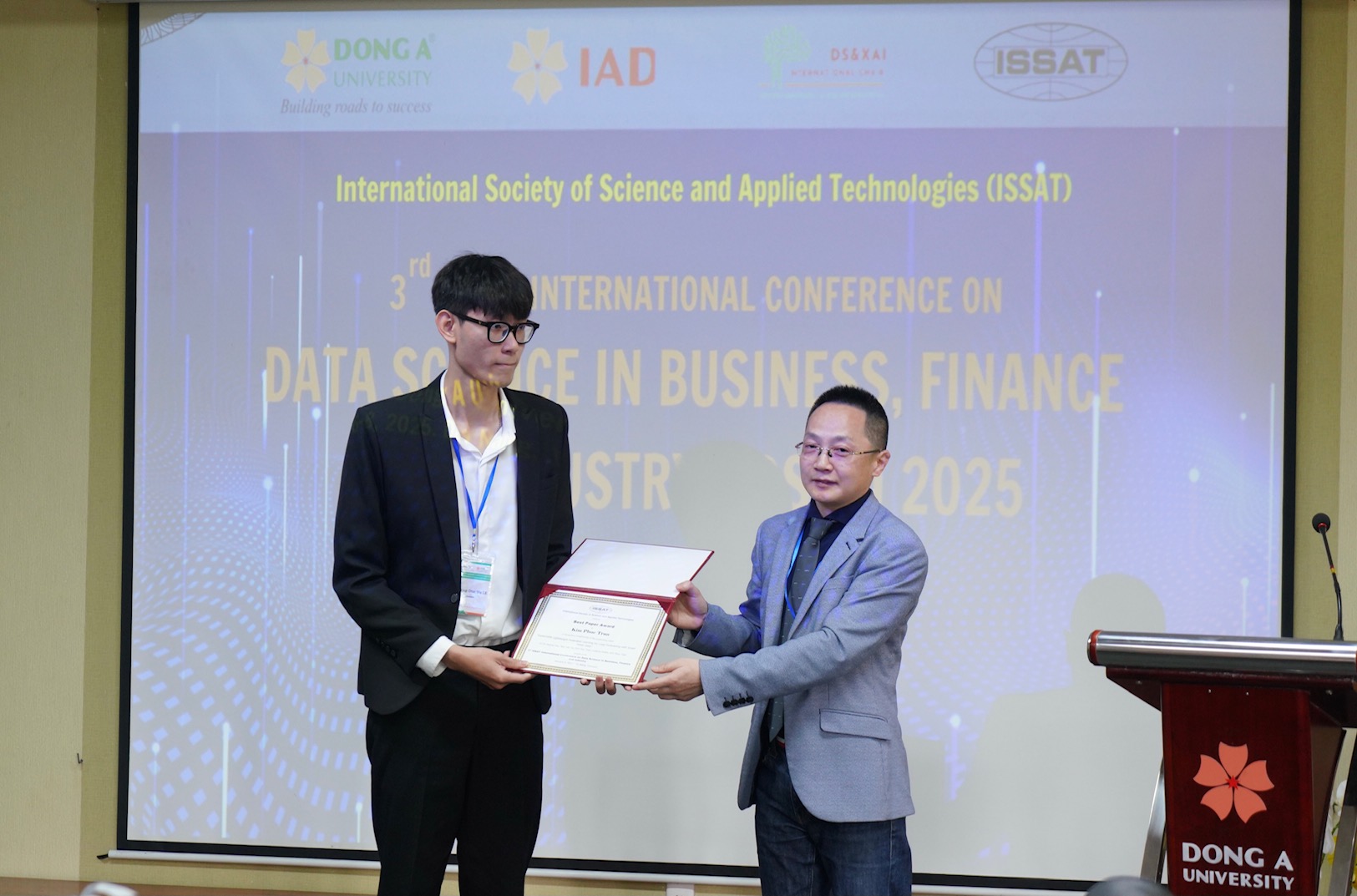 Đại diện ISSAT (b&ecirc;n phải) trao giải thưởng B&agrave;i b&aacute;o xuất sắc đến t&aacute;c giả c&oacute; c&ocirc;ng tr&igrave;nh nghi&ecirc;n cứu được đ&aacute;nh gi&aacute; cao tại hội thảo.