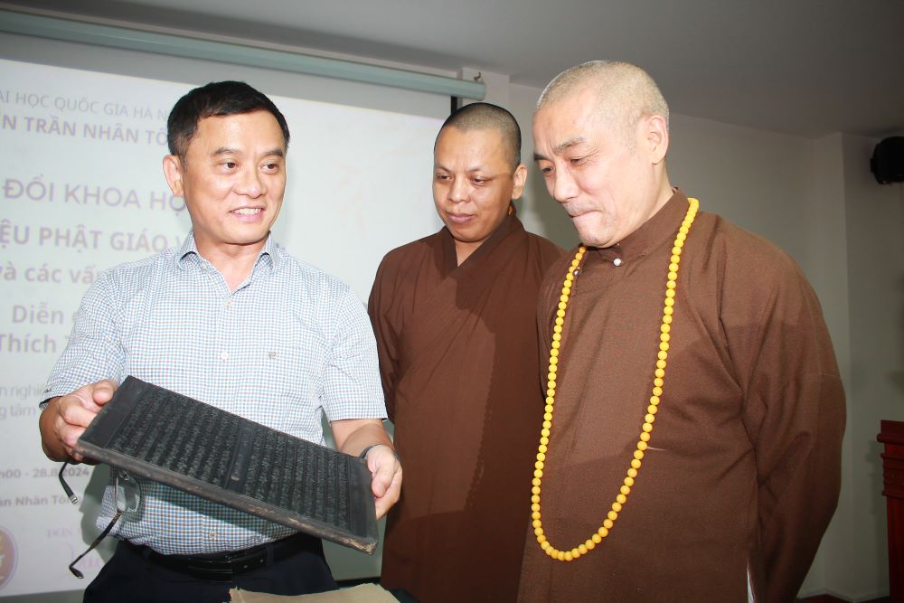 Thượng toạ Th&iacute;ch Tiến Đạt (ngo&agrave;i c&ugrave;ng b&ecirc;n phải) v&agrave;&nbsp;PGS. TS Nguyễn Tiến Vinh - Viện trưởng Viện Trần Nh&acirc;n T&ocirc;ng - Đại học Quốc gia H&agrave; Nội c&ugrave;ng xem một bản v&aacute;n in cổ.