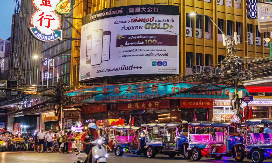 Ngoài quảng cáo các cửa hàng vàng, nhiều biểu hiệu ở khu phơ China Town, Bangkok, còn giới thiệu ứng dụng giao dịch vàng - Ảnh: Nikkei Asia