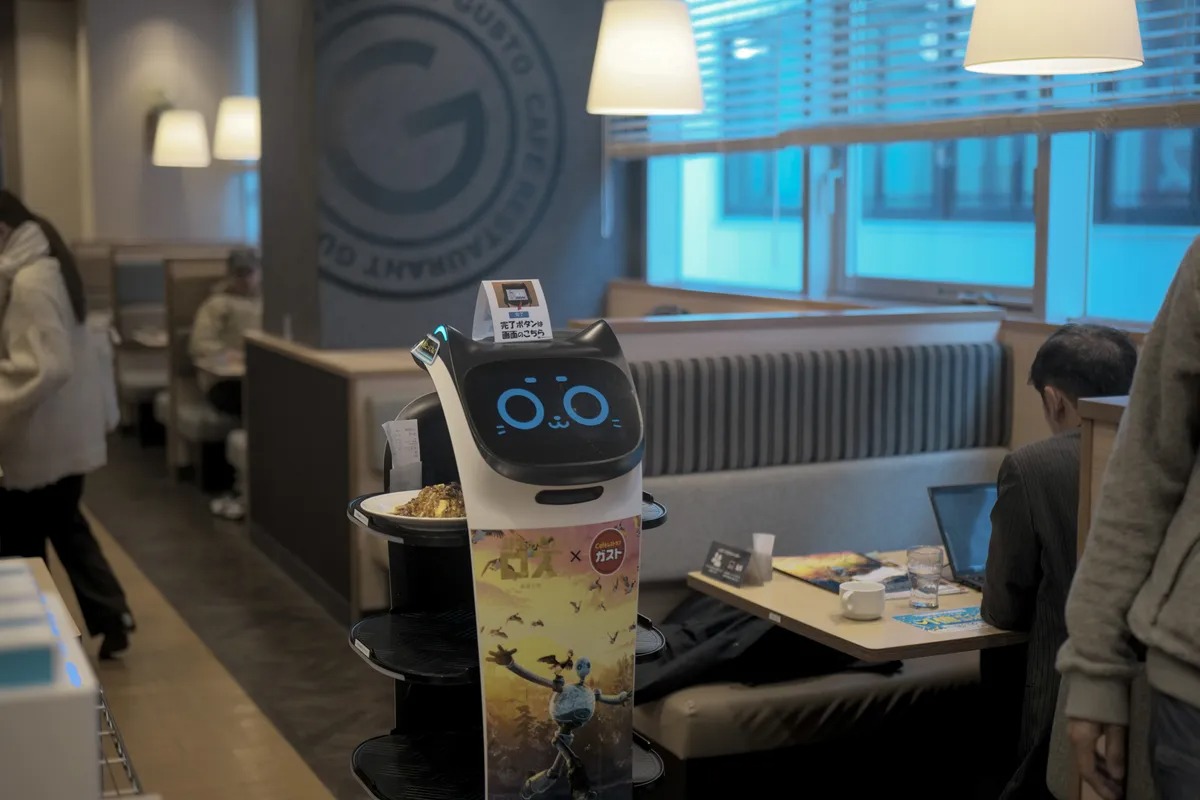 Một chú robot mèo đang phục vụ bàn tại nhà hàng Skylark ở Tokyo. Ảnh: Soichiro Koriyama/Bloomberg