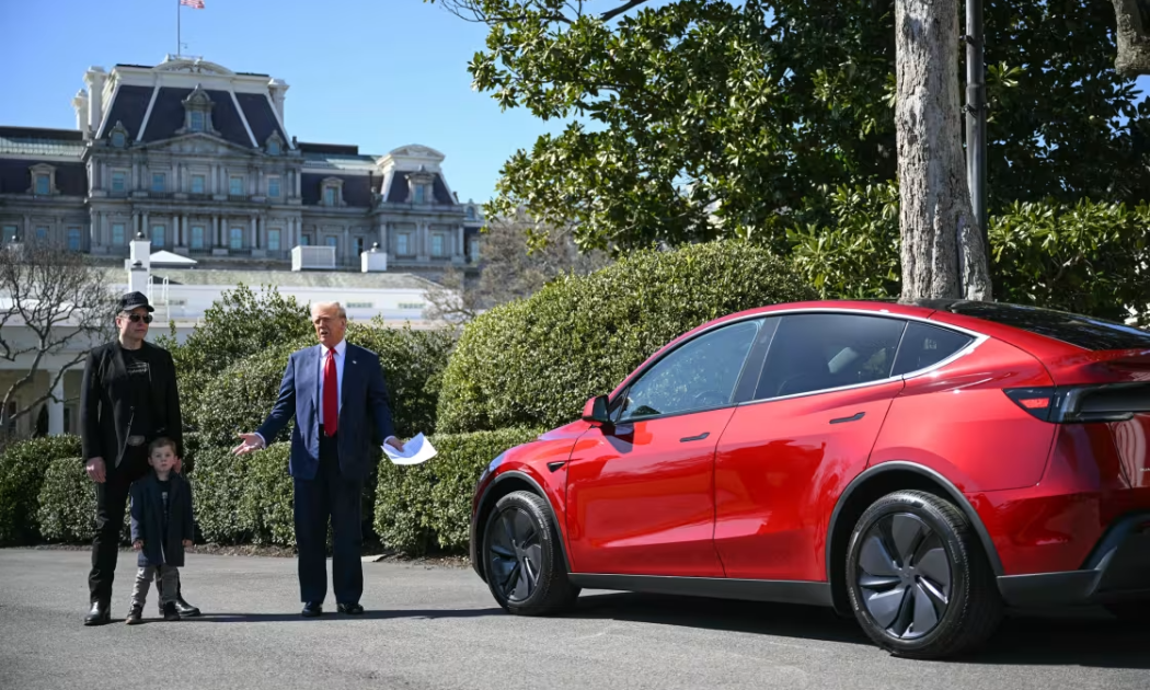 Tổng thống Donald Trump và CEO Tesla Elon Musk, phát biểu bên cạnh một chiếc xe Tesla tại bãi cỏ phía Nam Nhà Trắng ngày 11/3 - Ảnh: AP