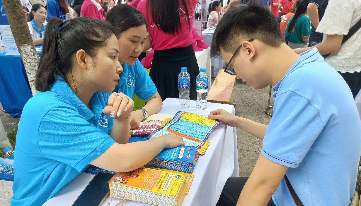 C&aacute;n bộ ng&agrave;nh Bảo hiểm x&atilde; hội th&ocirc;ng tin ch&iacute;nh s&aacute;ch đến người tham gia. Ảnh: Nhật Dương.