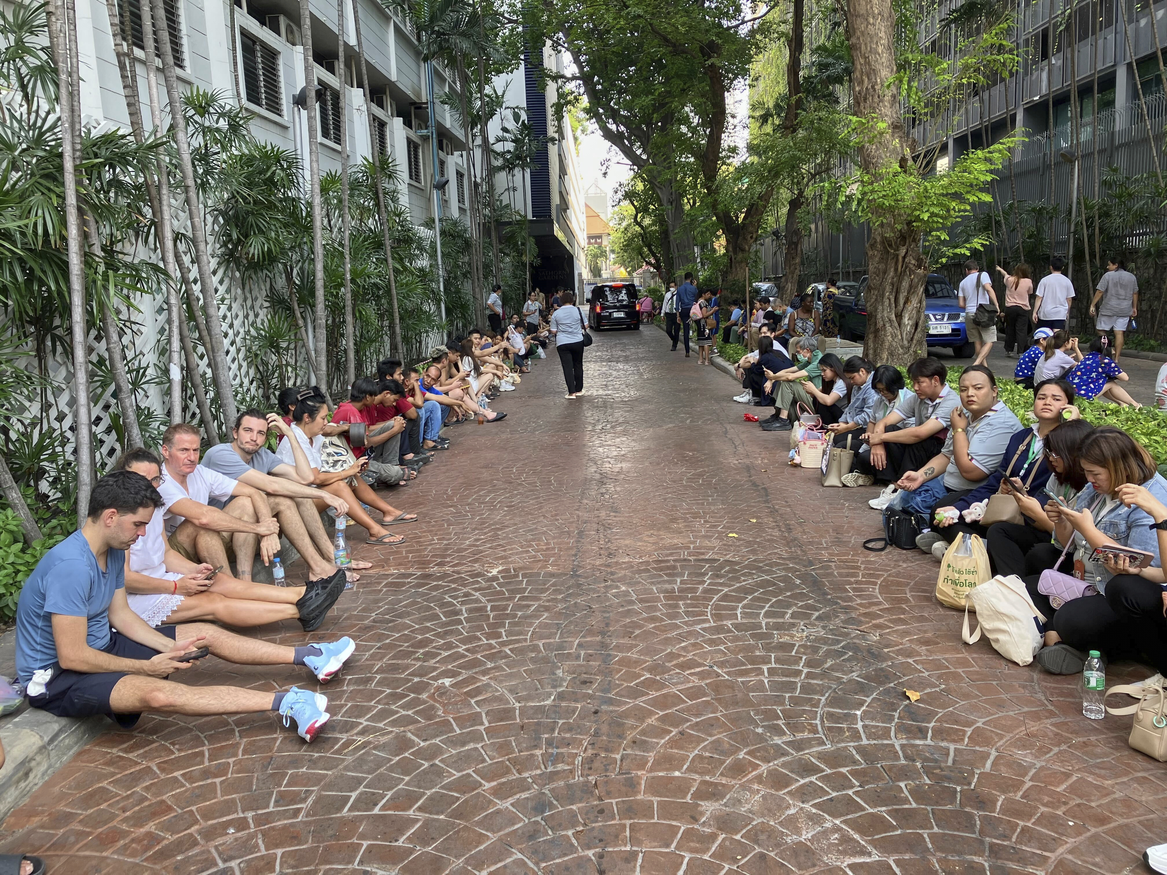 Người d&acirc;n v&agrave; du kh&aacute;ch chờ đợi th&ocirc;ng b&aacute;o an to&agrave;n để quay trở lại t&ograve;a nh&agrave; chung cư Sathorn Gardens sau trận động đất ở Bangkok, ng&agrave;y 28/3/2025