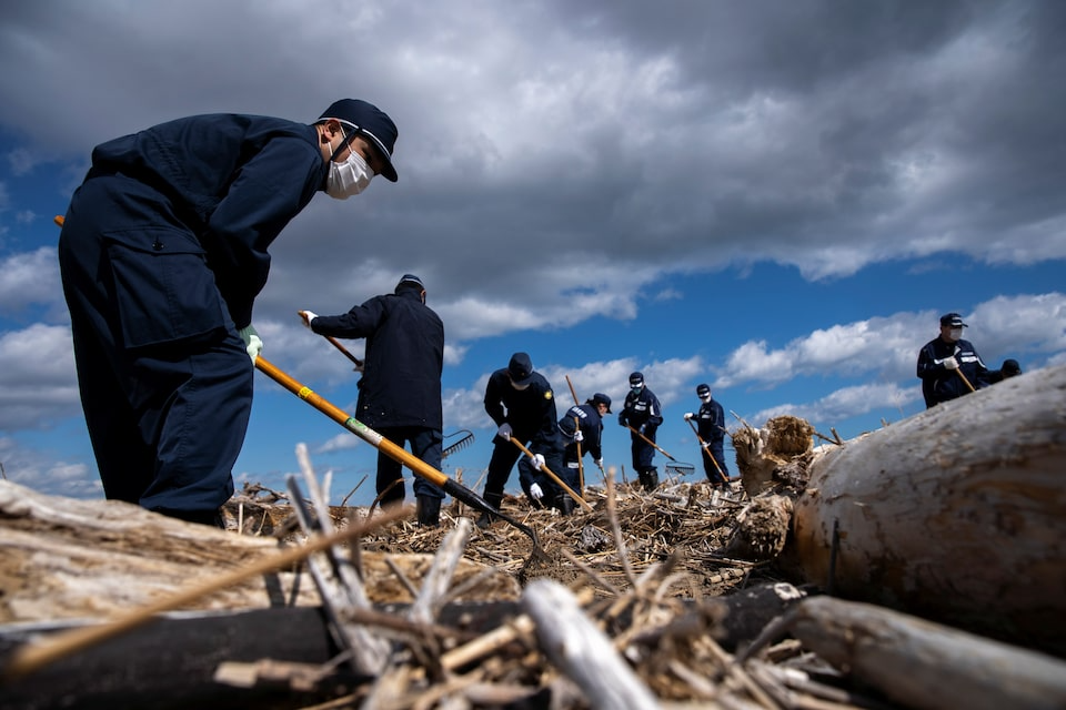 Lực lượng cứu hộ tìm kiếm nạn nhân sau thảm họa động đất và sóng thần ngày 11/3/2011 tại Namie, tỉnh Fukushima - Ảnh: Reuters
