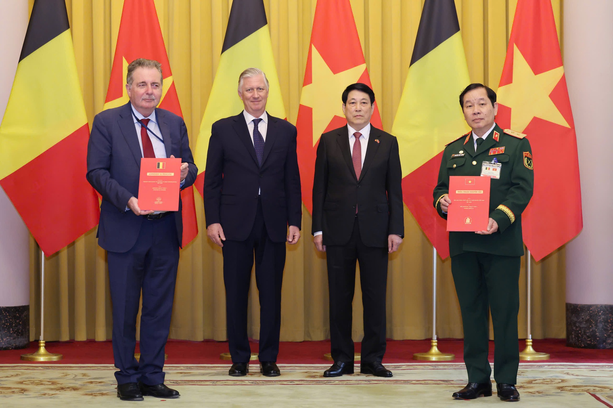 Chủ tịch nước Lương Cường và Nhà vua Bỉ Philippe chứng kiến Trung tướng Nguyễn Hữu Chính, Chủ tịch Hội Nạn nhân chất độc da cam/dioxin Việt Nam và Bộ trưởng, Thủ hiến Vùng Thủ đô Brussels Rudi Vervoort trao đổi Thỏa thuận nguyên tắc giữa Hội nạn nhân chất độc da cam/dioxin Việt Nam và Quỹ Aquitara Impact Fund 1 của Bỉ - Ảnh: VGP