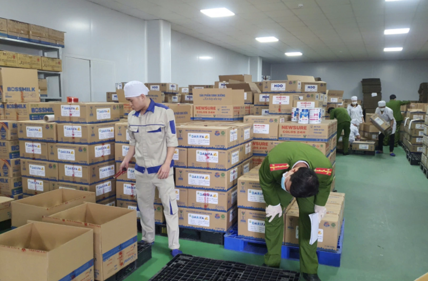 C&aacute;n bộ điều tra kiểm đếm sản phẩm sữa bột giả bị thu giữ. Ảnh: CAND