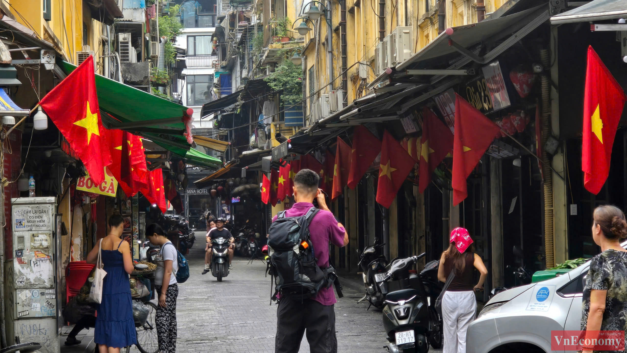 Nhiều kh&aacute;ch du lịch nước ngo&agrave;i cũng đến tham quan v&agrave; check-in tr&ecirc;n những con phố rực đỏ m&agrave;u cờ.