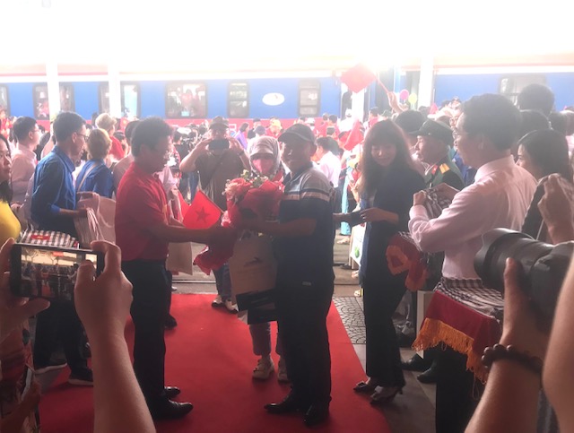 &Ocirc;ng Đặng Sỹ Mạnh (&aacute;o đỏ b&ecirc;n tr&aacute;i)- Chủ tịch Hội đồng th&agrave;nh vi&ecirc;n Tổng c&ocirc;ng ty Đường sắt Việt Nam, tặng hoa v&agrave; qu&agrave; h&agrave;nh kh&aacute;ch tr&ecirc;n t&agrave;u SE1 xuống ga Đ&agrave; Nẵng. Ảnh Ng&ocirc; Anh Văn